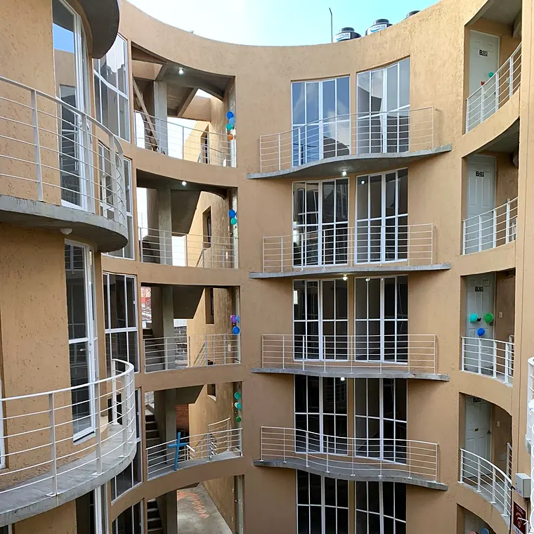 Patio central con balcones curvos del conjunto de 41 viviendas en la colonia Morelos